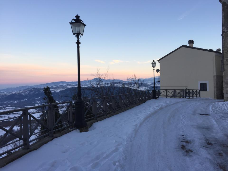 View of the end wall of the house and snow covered street